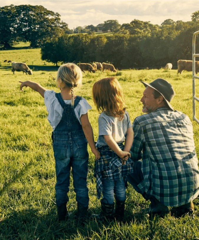 Farmer and his family observing grass fed cows